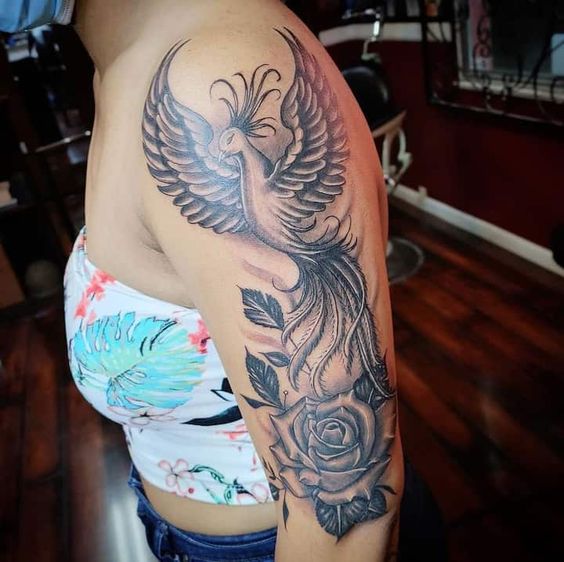 hình xăm phượng hoàng kết hợp với hoa hồng đơn sắc Hình xăm phượng hoàng và hoa hồng trên cánh tay, phong cách blackwork chi tiết, ảnh HD.