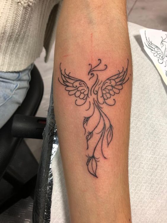 Hình xăm phượng hoàng blackwork trên cánh tay, phong cách đơn giản, chi tiết rõ nét, ảnh HD.