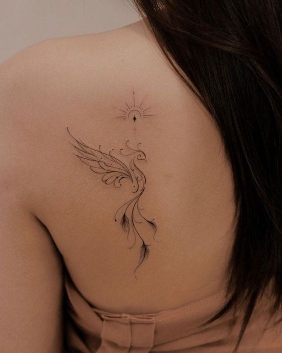 Hình xăm chim phượng hoàng trên lưng, phong cách blackwork, chi tiết tinh tế, ảnh độ phân giải HD.