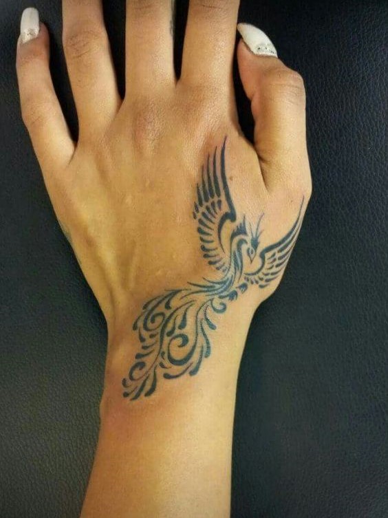 Hình xăm phượng hoàng mini trên mu bàn tay, phong cách blackwork, chi tiết rõ nét, ảnh độ phân giải HD.
