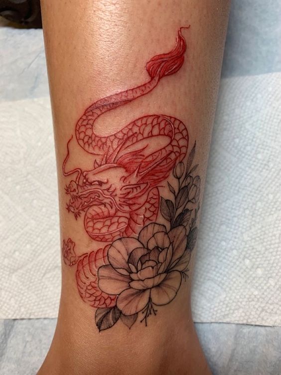 Hình xăm rồng đỏ và hoa trên chân, phong cách blackwork, chi tiết rõ nét, ảnh HD.