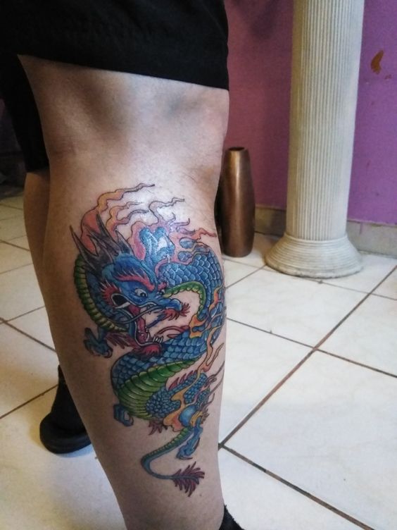 Hình xăm rồng màu sắc trên bắp chân, phong cách cổ điển, chi tiết rõ nét, ảnh chất lượng cao.