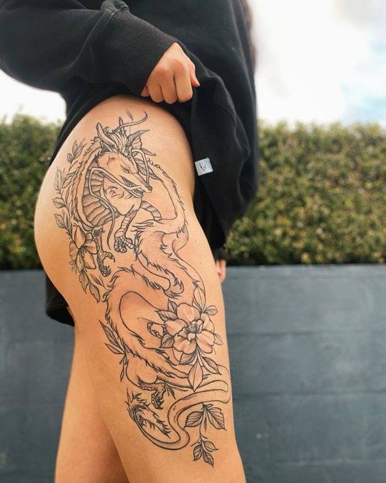 Hình xăm rồng và hoa trên đùi, phong cách blackwork chi tiết, ảnh chất lượng HD.