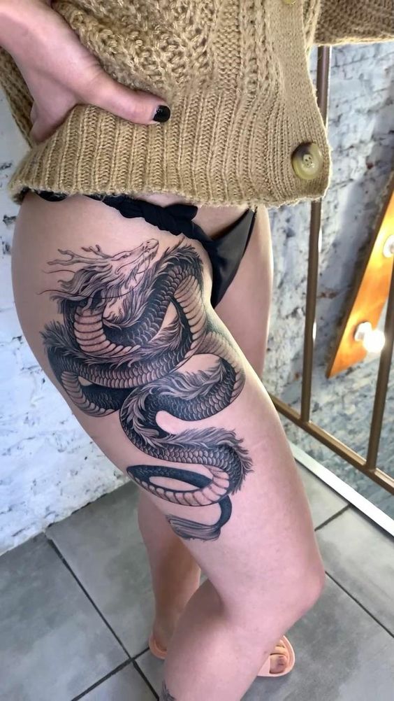 Hình xăm rồng blackwork chi tiết trên đùi, phong cách cổ điển, ảnh HD.