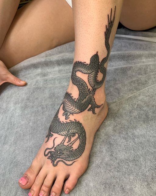 Hình xăm rồng blackwork chi tiết trên chân, phong cách cổ điển, độ phân giải HD.