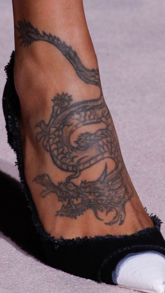 Hình xăm rồng trên chân, phong cách blackwork, chi tiết rõ nét, ảnh độ phân giải cao.