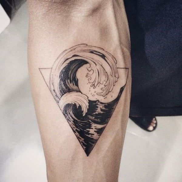 Hình xăm sóng biển phong cách blackwork trên cánh tay, chi tiết sắc nét, chất lượng HD.