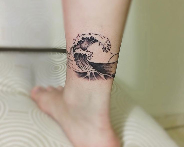 Hình xăm sóng biển trên chân phong cách blackwork chi tiết, độ phân giải HD.