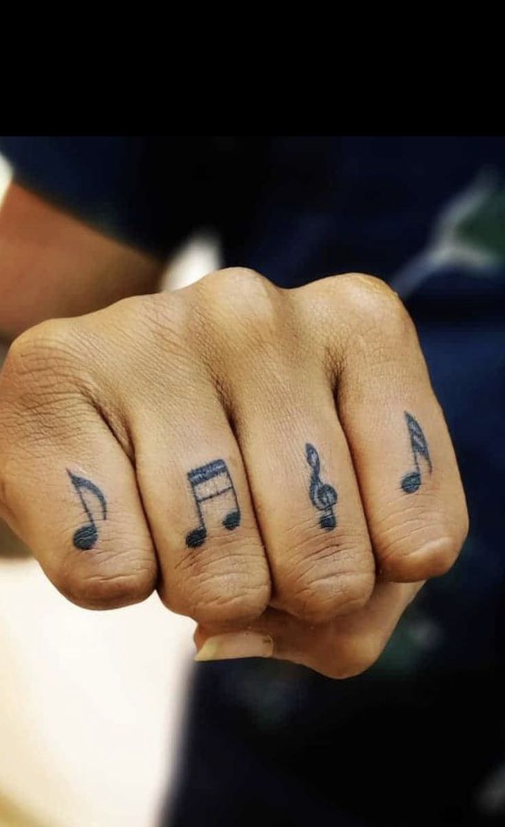 Hình xăm nốt nhạc trên ngón tay theo phong cách blackwork, chi tiết rõ nét, độ phân giải HD.