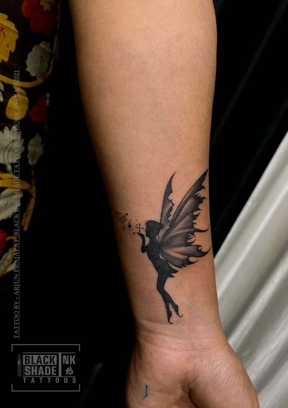 Hình xăm tiên mini trên cánh tay, phong cách blackwork, chi tiết rõ nét, độ phân giải HD.