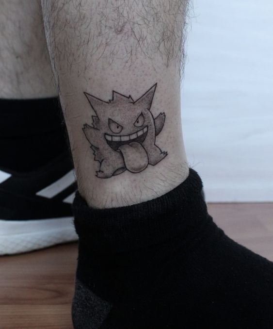 hình xăm trắng đen mini độc đáo Hình xăm nhân vật hoạt hình trên bắp chân, phong cách blackwork đơn giản, ảnh HD.
