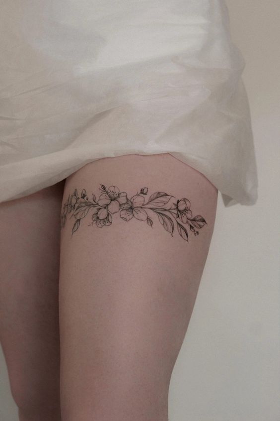 Hình xăm hoa trên đùi, phong cách blackwork, chi tiết tinh tế, ảnh độ phân giải HD.