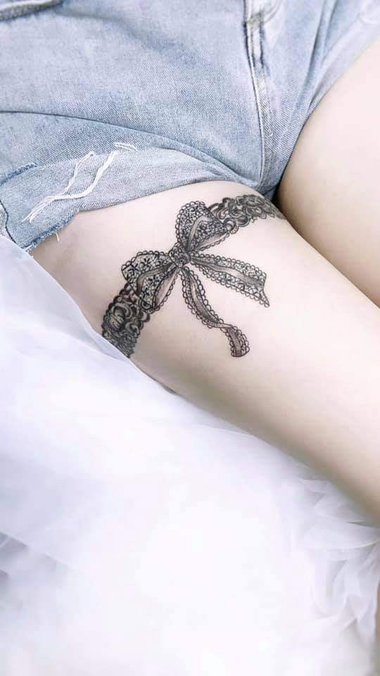 Hình xăm vòng ren thắt nơ Hình xăm nơ ren trên đùi, phong cách blackwork chi tiết, ảnh HD, tạo cảm giác tinh tế và nữ tính.