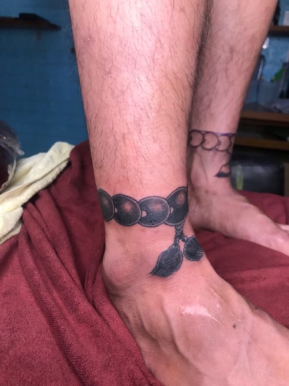 Hình xăm vòng chuỗi cổ chân phong cách blackwork, chi tiết cao, độ phân giải HD.
