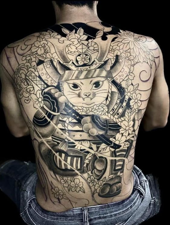 Hoàn thiện hình xăm mèo samurai kết hợp họa tiết hoa anh đào đơn sắc kín lưng cho khách Hình xăm mèo samurai trên lưng, phong cách blackwork, chi tiết rõ nét, độ phân giải HD.