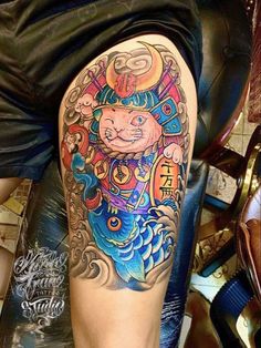 Khách xăm hình mèo samurai trên đùi Hình xăm mèo thần tài phong cách màu sắc, chi tiết trên đùi. Độ phân giải HD.