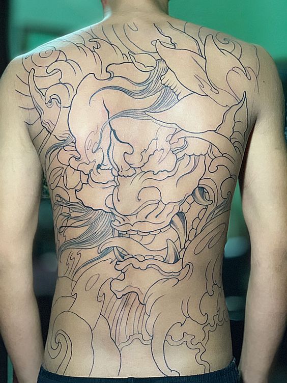 Hình xăm mặt quỷ phong cách blackwork trên lưng, chi tiết cao, ảnh HD.