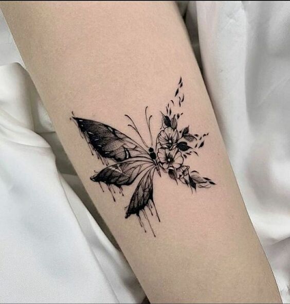Hình xăm bướm và hoa trên tay, phong cách blackwork, chi tiết rõ nét, độ phân giải HD.