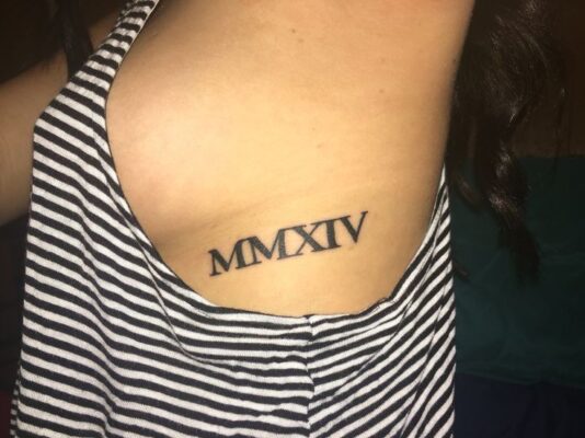 Hình xăm chữ số La Mã trên sườn, phong cách blackwork, ảnh độ phân giải HD.