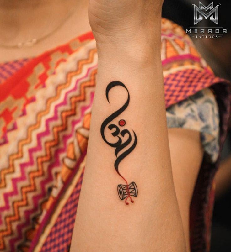 kiểu xăm chữ phạn cực đẹp ở tay Hình xăm Om trên cánh tay, phong cách blackwork, chi tiết tinh tế, độ phân giải HD.