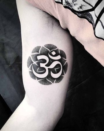 Xăm chữ Phạn họa tiết đẹp Hình xăm ký hiệu Om trên bắp tay, phong cách blackwork chi tiết, độ phân giải cao.