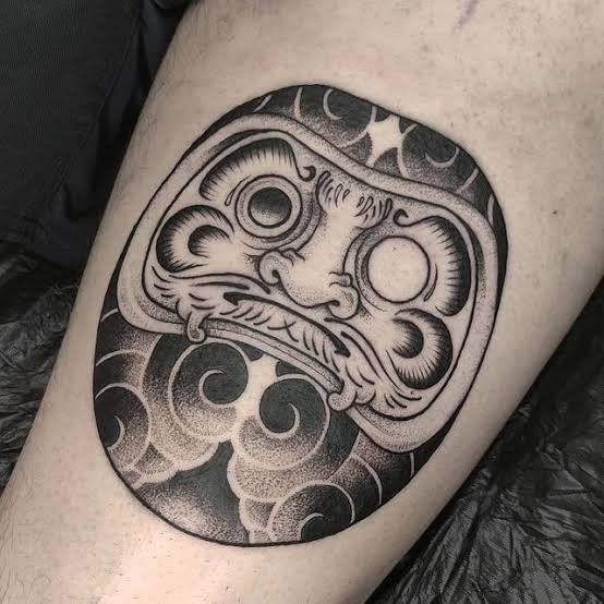 kiểu xăm hình daruma đen trắng truyền thống cho khách Hình xăm mặt nạ Daruma trên đùi, phong cách blackwork chi tiết, ảnh HD.