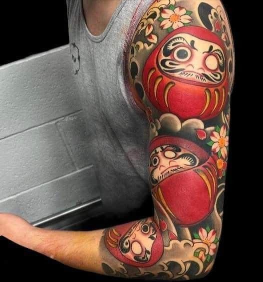 hình xăm daruma đa diện phủ kín cánh tay, kết hợp với hoa anh đào trắng Hình xăm búp bê Daruma trên cánh tay, phong cách màu sắc, chi tiết rõ nét, độ phân giải HD.