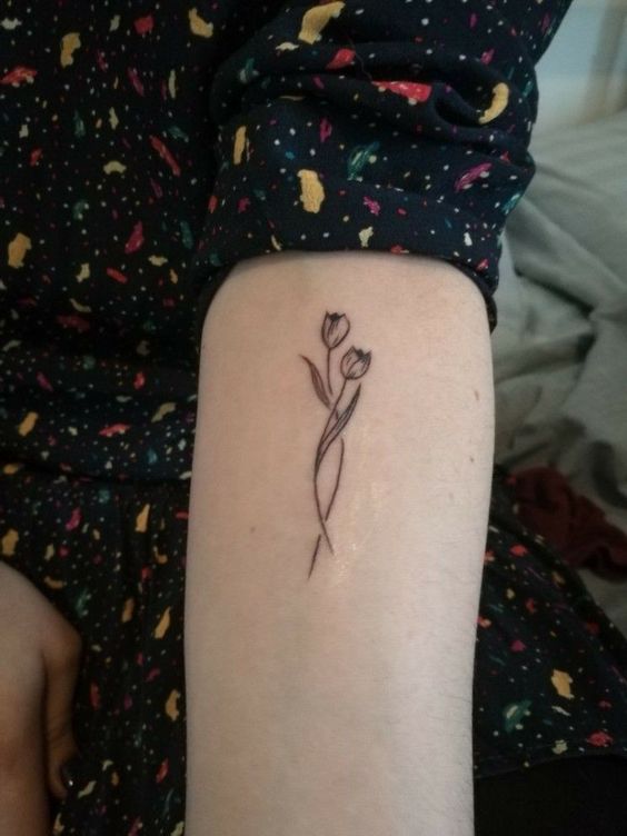 Hình xăm hoa tulip tối giản ở cánh tay, phong cách blackwork, độ chi tiết cao, ảnh HD.