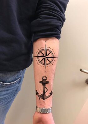Hình xăm la bàn và mỏ neo trên cánh tay, phong cách blackwork, độ chi tiết cao, ảnh độ phân giải HD.