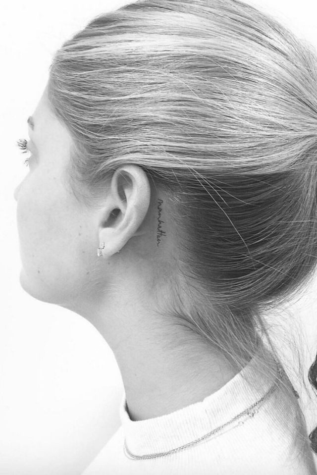 Hình xăm chữ mini sau tai phong cách blackwork, chi tiết rõ nét, ảnh đen trắng, độ phân giải HD.