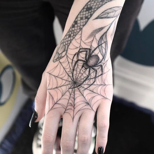 Hình xăm mạng nhện và nhện trên mu bàn tay, phong cách blackwork, chi tiết rõ nét, độ phân giải HD.