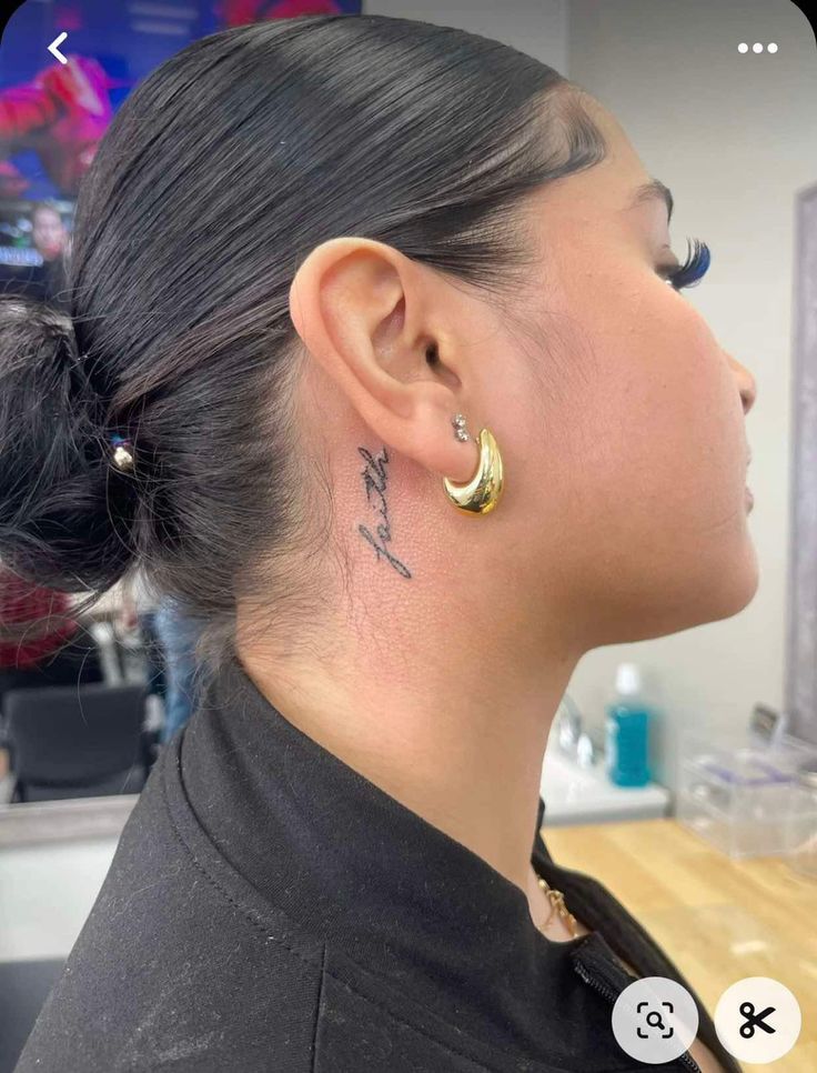 Hình xăm chữ "faith" sau tai, phong cách tối giản, ảnh HD rõ nét.