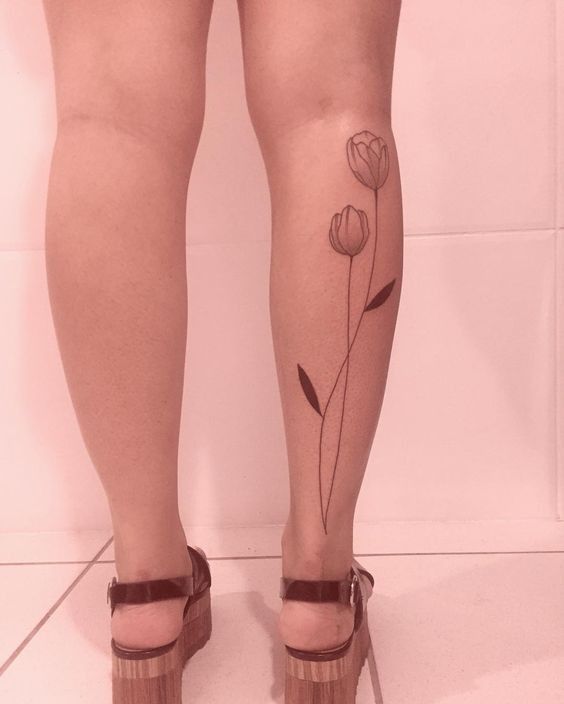 Hình xăm hoa tulip tối giản trên bắp chân, phong cách blackwork, độ phân giải HD.