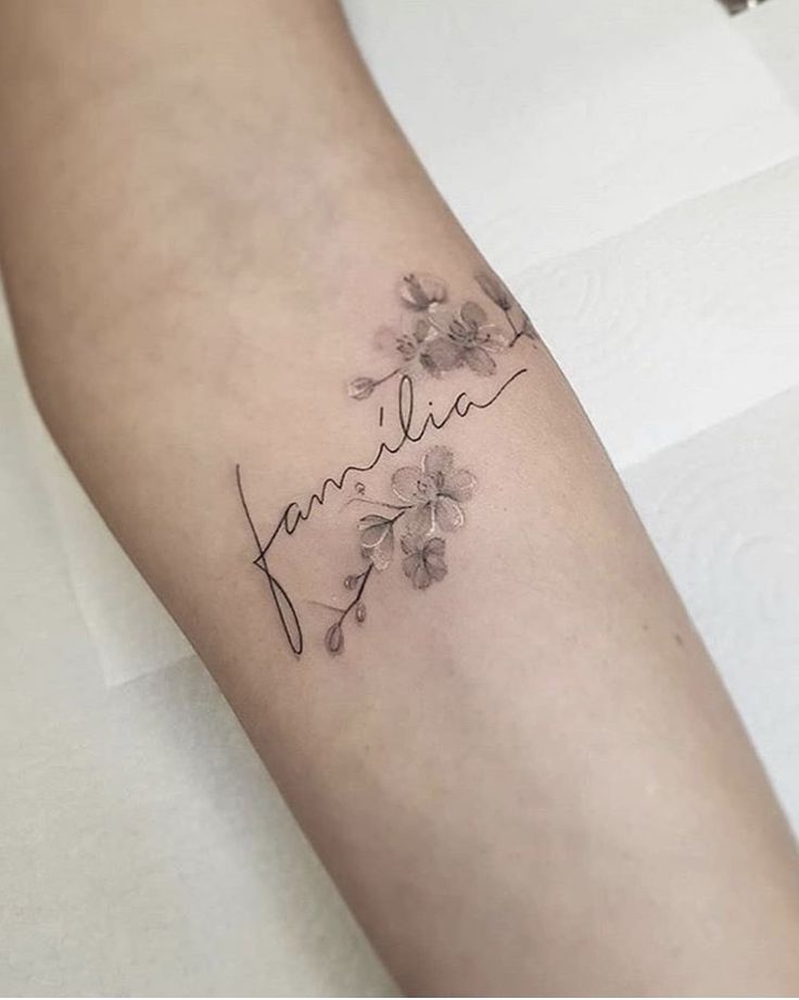 Mẫu hình xăm chữ gia đình mini Hình xăm chữ "familia" và hoa trên cánh tay, phong cách blackwork, chi tiết tinh tế, độ phân giải HD.
