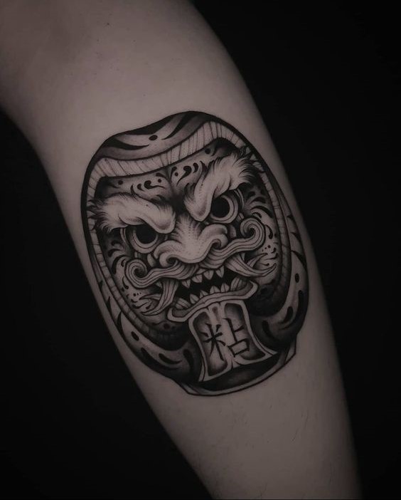 Mẫu hình xăm Daruma thể hiện ý chí kiên trì, tạo động lực Hình xăm mặt nạ Nhật Bản trên bắp tay, phong cách blackwork chi tiết, độ phân giải cao.