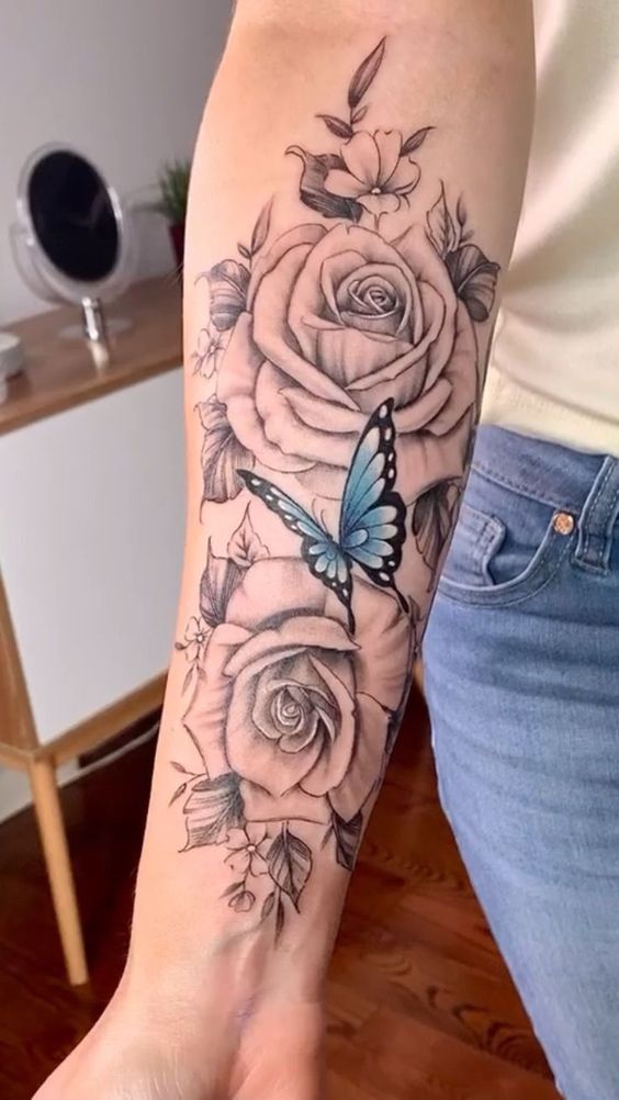 Mẫu hình xăm hoa hồng phá cách Hình xăm hoa hồng và bướm trên cánh tay, phong cách blackwork, chi tiết rõ nét, độ phân giải HD.