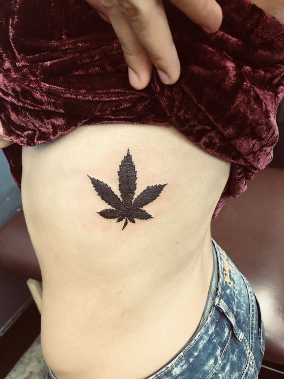 Hình xăm lá cần sa trên hông, phong cách blackwork, chi tiết rõ nét, ảnh HD.