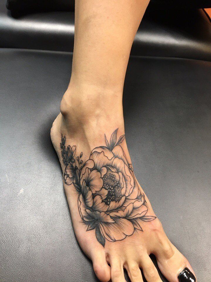 Hình xăm hoa phong cách blackwork trên mu bàn chân, chi tiết cao, ảnh HD.