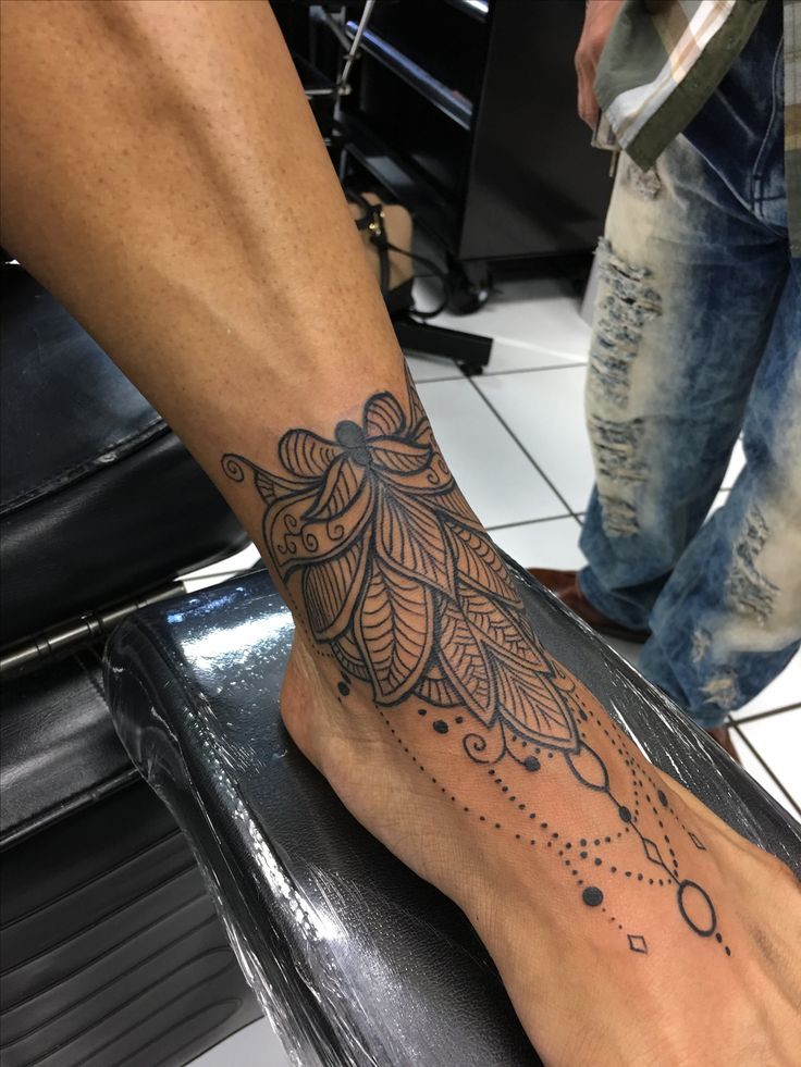 Hình xăm hoa văn đen cổ điển trên mu bàn chân, chi tiết sắc nét, phong cách blackwork, ảnh HD.