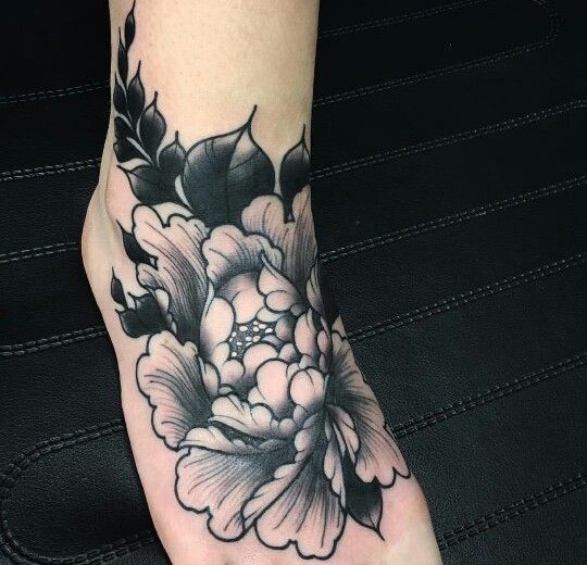 Hình xăm hoa trên chân, phong cách blackwork, chi tiết rõ nét, độ phân giải cao.