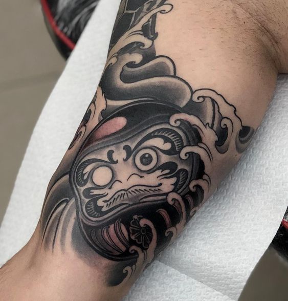 Mẫu khách xăm daruma mặt vuông cho bắp tay Hình xăm Daruma trên cánh tay, phong cách blackwork chi tiết, độ phân giải HD.