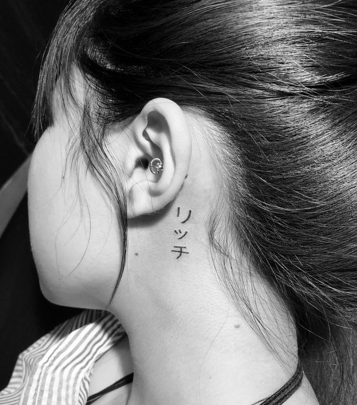 Hình xăm chữ Nhật sau tai phong cách blackwork, ảnh HD đen trắng, chi tiết rõ nét.