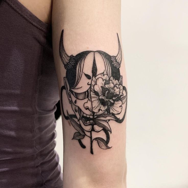 Hình xăm mặt nạ Oni và hoa trên tay, phong cách blackwork chi tiết, ảnh độ phân giải cao.