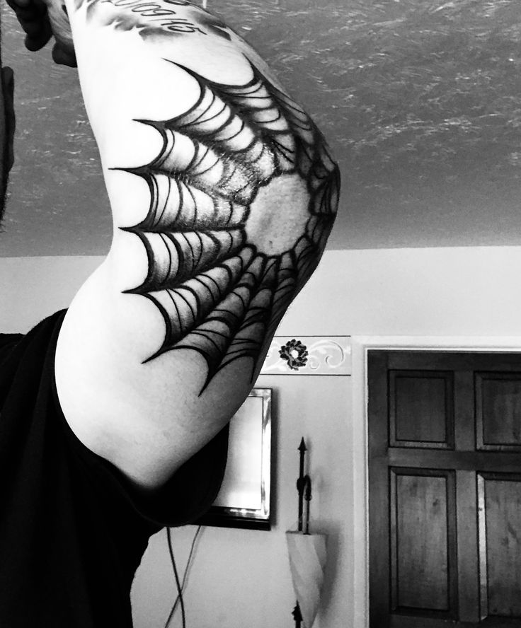 Hình xăm mạng nhện trên bắp tay, phong cách blackwork, chi tiết rõ nét, ảnh độ phân giải cao.