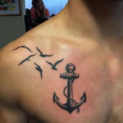 Hình xăm mỏ neo và chim trên vai, phong cách blackwork, chi tiết rõ nét, ảnh độ phân giải HD.
