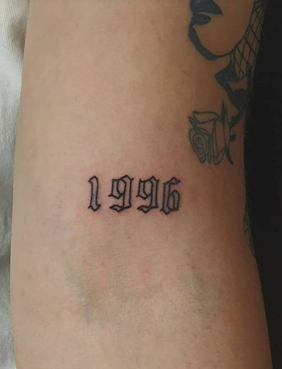 Hình xăm số 1996 trên cánh tay, phong cách cổ điển, chi tiết rõ nét, độ phân giải HD.