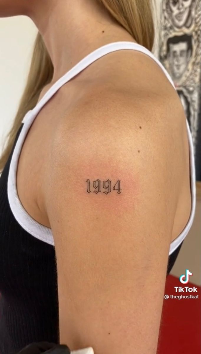 Hình xăm số 1994 trên vai, phong cách blackwork, chi tiết rõ nét, ảnh HD.
