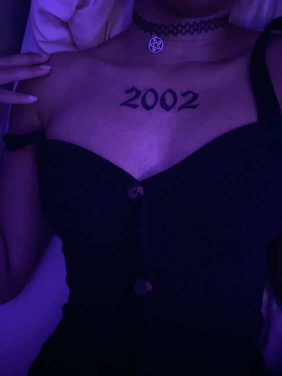 Hình xăm số "2002" trên ngực, phong cách blackwork, chi tiết rõ nét, ảnh HD.