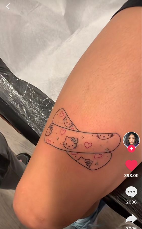Hình xăm băng cá nhân Hello Kitty trên đùi, phong cách dễ thương, chi tiết rõ nét, độ phân giải HD.
