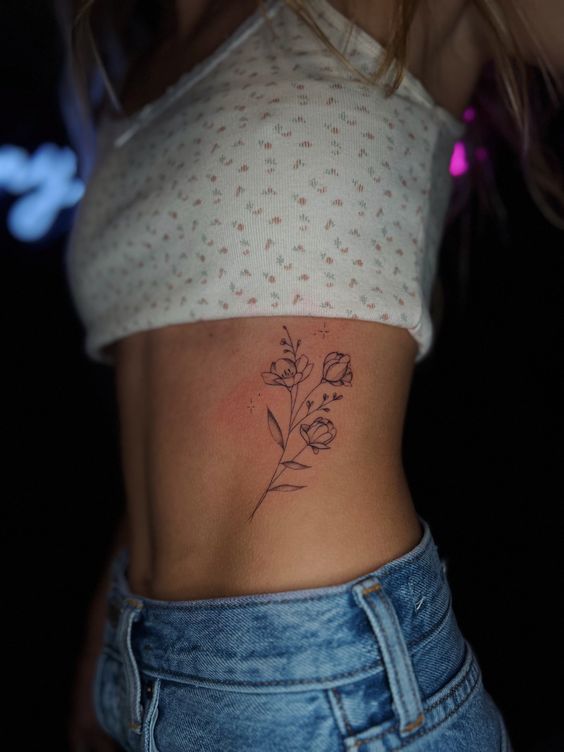Hình xăm hoa tối giản trên sườn, phong cách blackwork, chi tiết tinh tế, ảnh HD.